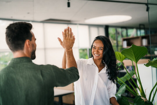 Cheerful diverse coworkers having fun during work break using technology enjoying working together