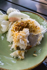 Savory Minapadi chicken curry served with fluffy rice, crispy fried onions, crackers, and spicy...