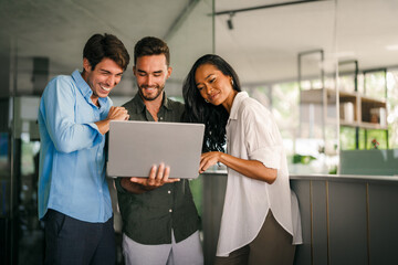 Diverse startup, business people working together on laptop computer in modern office