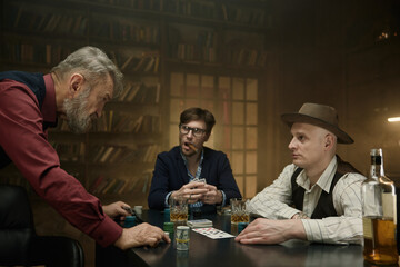 Determined man tensely making his move in a poker game in a vintage bar