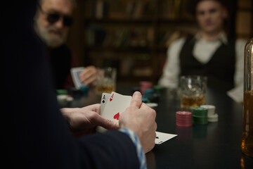 Serious determined man thinking about the course of the poker game in a vintage bar