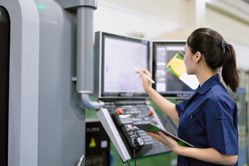 young technician engineer worker with CNC lathe metal machine in modern steel industry factory