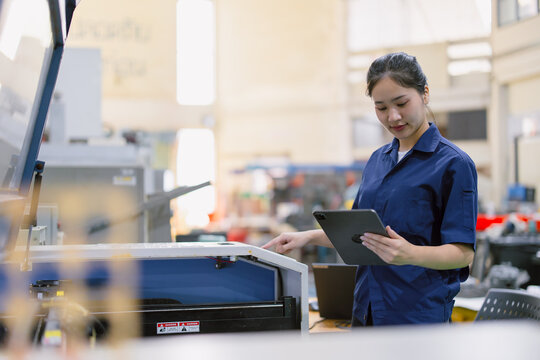young technician engineer worker with Metal Laser cutting machine in modern steel industry factory