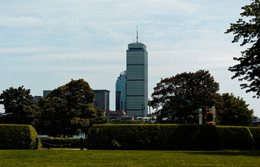 Cambridge, Massachusetts, USA – August 11, 2009: Office building towers above lush green park in...