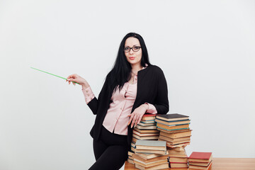 teacher with stacks of books on table