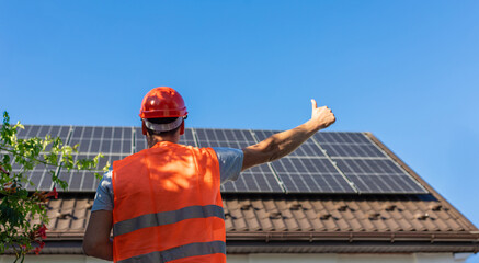 Engineer Showing Thumbs Up at Solar Panels on House Roof