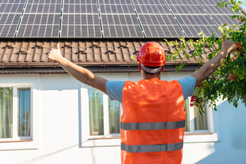Engineer Showing Thumbs Up at Solar Panels on House Roof