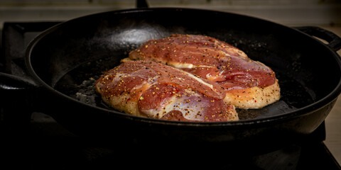 two duck breasts are fried in a pan, seasoned with salt and a mixture of peppers