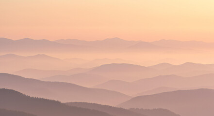 Fototapeta premium Softly lit mountain peaks in a hazy sunrise