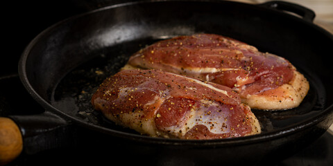 two duck breasts are fried in a pan, seasoned with salt and a mixture of peppers