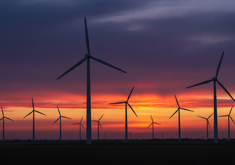 Wind Turbines at Sunset: A breathtaking view showcases a field of wind turbines silhouetted against a stunning sunset, a symbol of sustainable energy and eco-friendliness. 