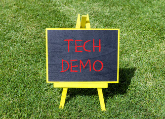 Tech demo symbol. Concept word Tech demo on beautiful black blackboard. Beautiful green grass lawn...