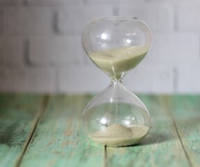 Hourglass in wooden table close up photo time	
