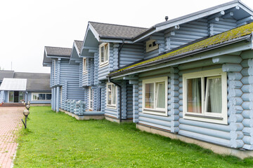 Modern log house, wooden holiday home, blue wooden house with big windows, balcony and veranda,...