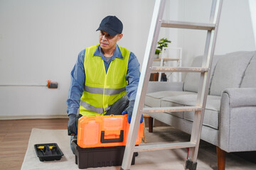 Professional handyman preparing tools for home improvement project in living room setting with...