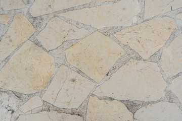 Textura de piso de piedra irregular con juntas visibles en tonos beige