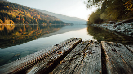 Beautiful wooden dock extends over calm lake surrounded by mountains at sunset