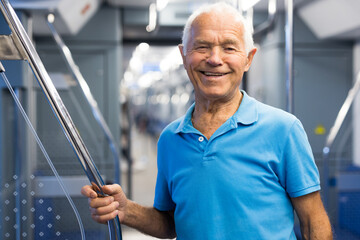 Old man standing in subway car