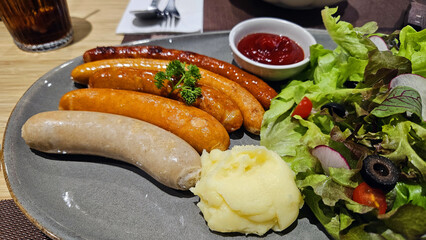 Many pork, beef, chicken sausages, mashed potatoes and fresh organic vegetables with lettuce,...
