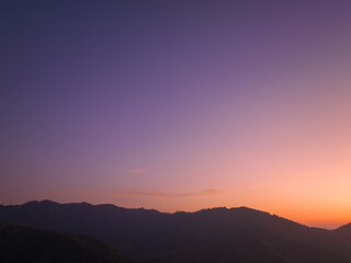 aerial view amazing colors in the sky at dawn over the misty sea in the valley. colorful sky at twilight above the mountain range. Mist covers the complicated mountain ranges.