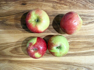 Four Fresh Apples on Wooden Surface
