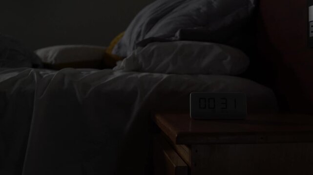 Man struggling with insomnia tossing and turning in bed