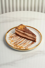 A piece of ferrero cake on a plate, on a light background