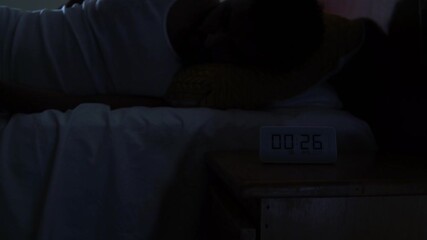 Woman suffering from insomnia tossing and turning in bed