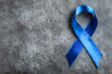 Blue ribbon on grey background, top view with space for text. Symbol of social and medical issues