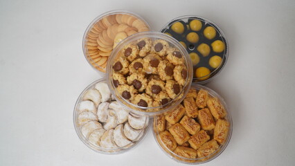 Five transparent plastic jars filled with: Nastar, Kastengel, Lidah Kucing, Putri Salju, and...