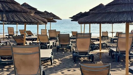 Enjoying a peaceful and relaxing time at a beautiful beach with lounge chairs and umbrellas by the calm ocean waters