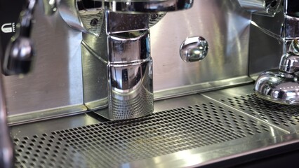 Chrome plated group head dispensing rich espresso, reflecting ceiling lights on gleaming surface inside traditional Lombardy coffee bar