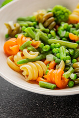 Trottole pasta vegetables green peas, green beans, kohlrabi cabbage, broccoli second course tasty snack fresh delicious gourmet food background on the table rustic food top view copy space