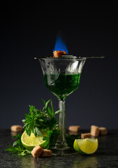 Burning sugar on a glass with absinthe.