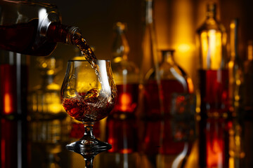 Pouring brandy from a bottle into a glass.