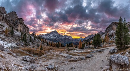 Dramatic sunset over a mountain pass with colorful clouds.