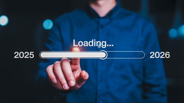 Person s finger touches loading bar transitioning from year 2025 to 2026 with blurred lights background