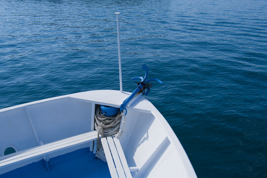 Bug eines wei&szlig;en Schiffes mit einem blauen Anker auf dem Meer