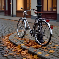 Fototapeta premium Classic bicycle parked on cobblestone street with fallen autumn leaves and vintage city background with copy space