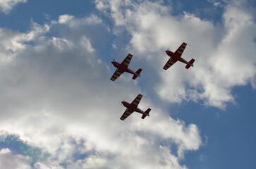 Air show during Polish Aviation Day in Krakow, Poland. Military and civil aircraft performing aerobatic maneuvers in the sky.