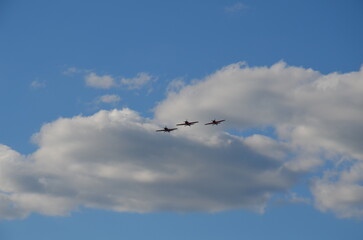 Air show during Polish Aviation Day in Krakow, Poland. Military and civil aircraft performing aerobatic maneuvers in the sky.