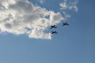 Air show during Polish Aviation Day in Krakow, Poland. Military and civil aircraft performing aerobatic maneuvers in the sky.