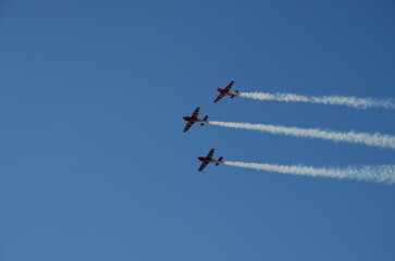 Air show during Polish Aviation Day in Krakow, Poland. Military and civil aircraft performing aerobatic maneuvers in the sky.