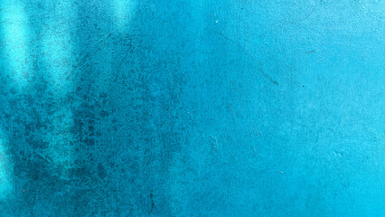 Close-up of a blue painted wall with visible grunge stains and subtle scratches