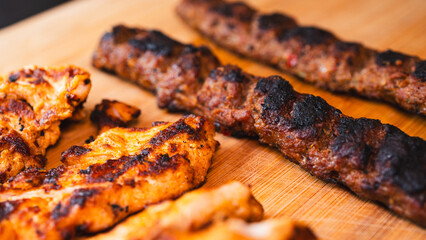 Delicious and healthy mixed grill platter featuring juicy chicken shish, tender lamb shish, and sliced chicken doner kebab. Served on a rustic wooden board. Perfect for food blogs, menus and more.