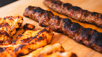 Delicious and healthy mixed grill platter featuring juicy chicken shish, tender lamb shish, and sliced chicken doner kebab. Served on a rustic wooden board. Perfect for food blogs, menus and more.