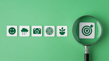 Magnifying glass focuses on target icon amidst row of diverse lifestyle and goal oriented symbols