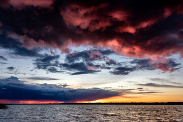 Krajobraz dramatycznego zachodzącego słońca nad jeziorem