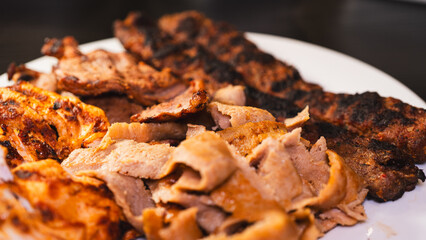 Delicious and healthy mixed grill platter featuring juicy chicken shish, tender lamb shish, and sliced chicken doner kebab. Served on a rustic wooden board. Perfect for food blogs, menus and more.