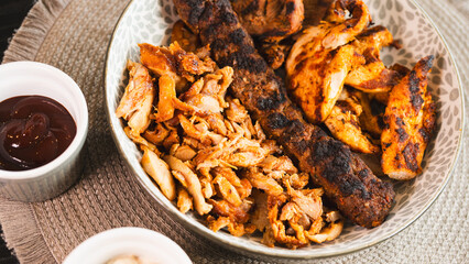 A beautifully arranged platter of grilled chicken shish, lamb shish, and doner kebab, served with vibrant sauces on the side. Elegant plating for food photography, menus, and promoting healthy, protei